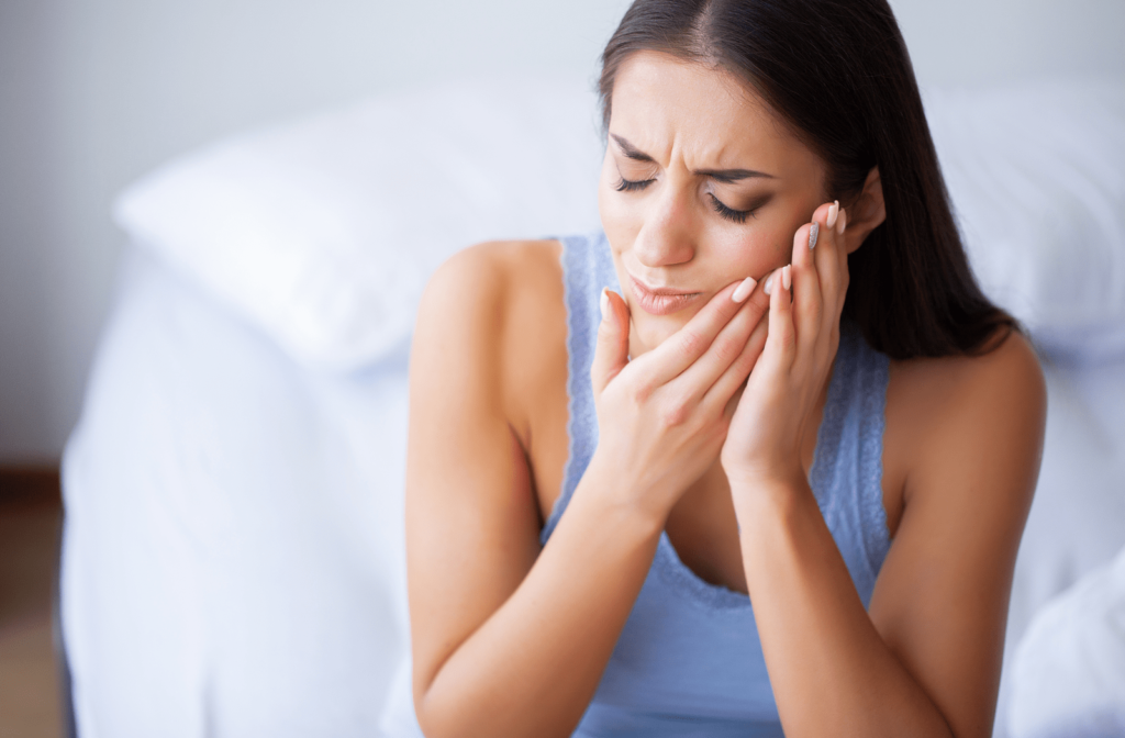 Woman with a toothache touching her jaw in pain