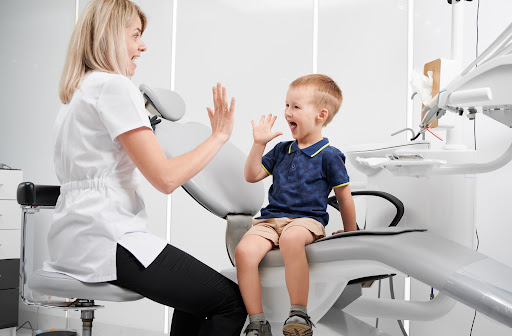 Happy boy high-fiving dentist after dental exam