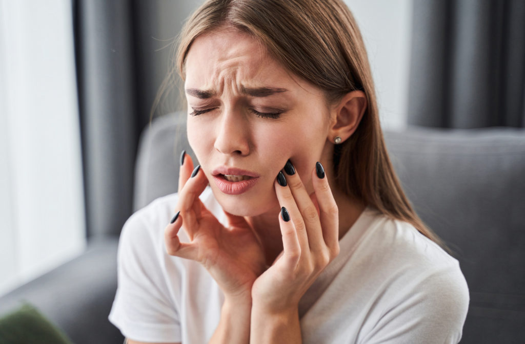 Women experiencing toothache which she will need to go to dentist for emergency visit