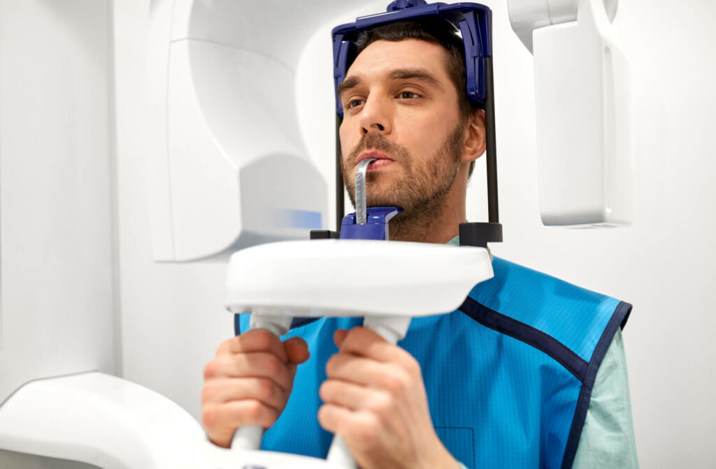 A male patient undergoing a panoramic X-ray scan procedure at a dental clinic.