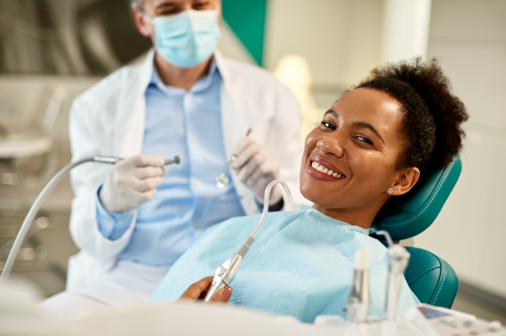 A smiling patient relaxes in a dental chair, preparing for a routine checkup.