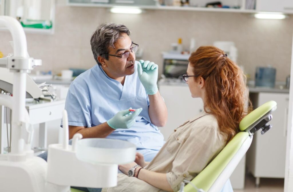 A dentist explains the dental freezing process to their patient before treatment.