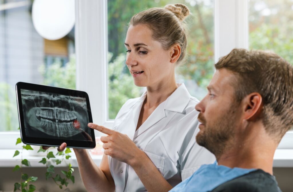 A dentist reviews their patient's digital X-rays with them.