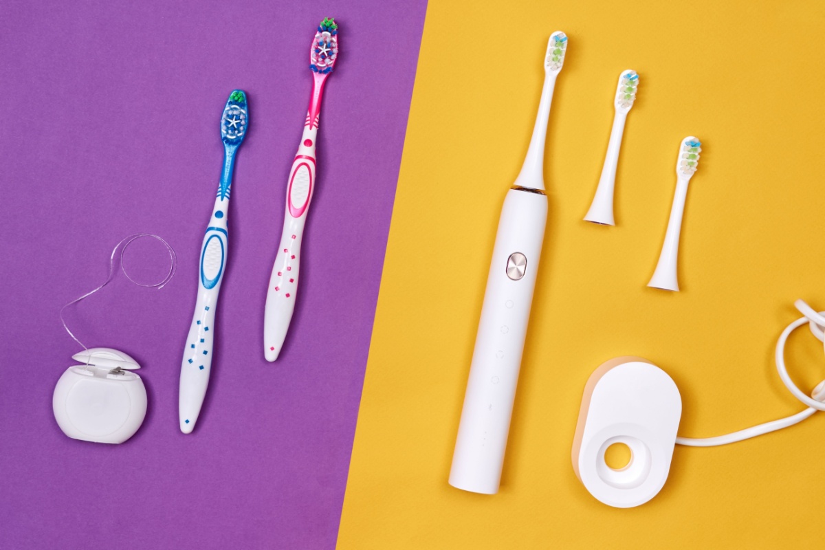 Split composition comparing manual and electric toothbrush options on purple and yellow backgrounds, showing colorful children's manual toothbrushes with dental floss on left and white electric toothbrush with replacement heads and charging base on right.